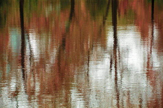 Abstract reflection of autumn trees in rust, olive, aqua and brown tones across rippling water, presented as contemporary metal wall art.