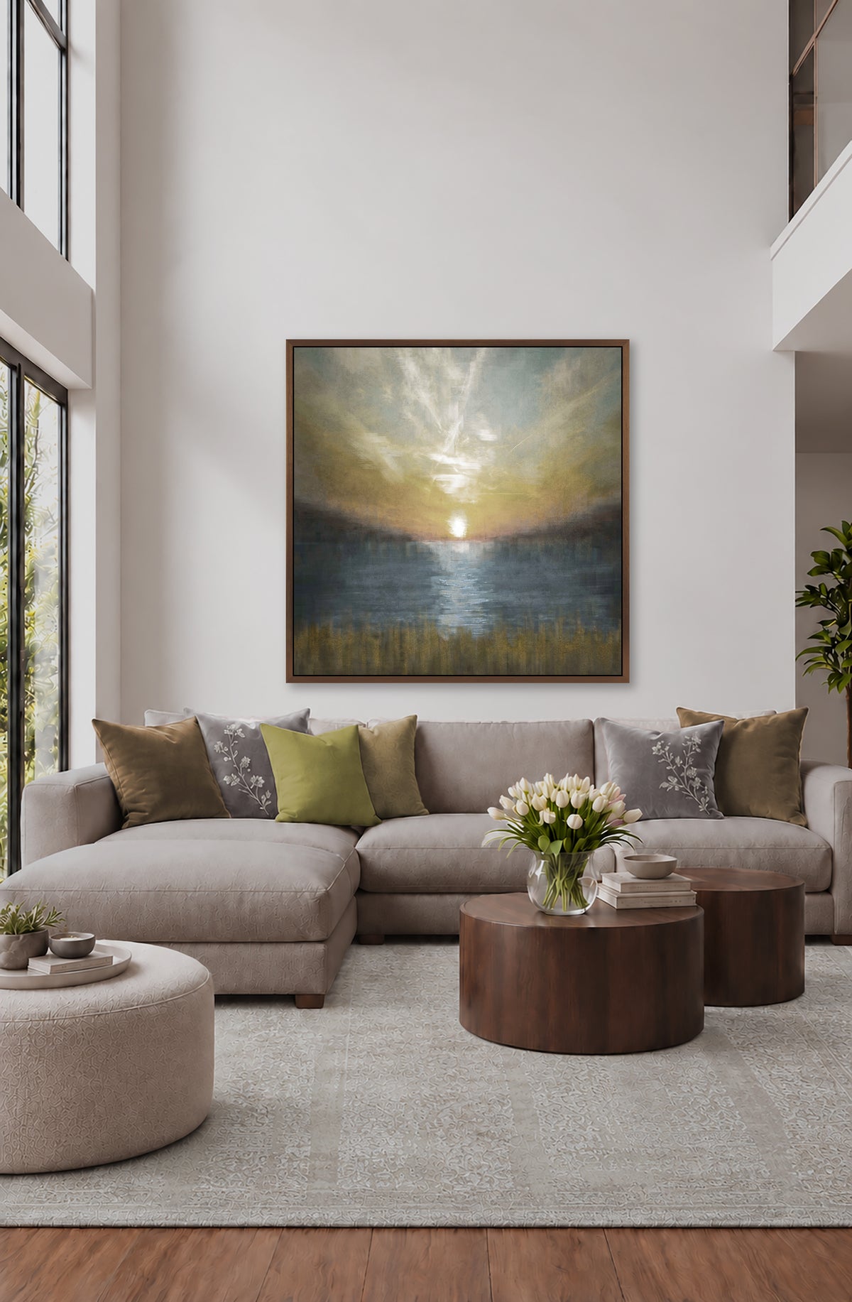 a modern living room with a large painting of a sunset on the wall above a gray sectional sofa. The sofa is adorned with throw pillows in various colors, and there is a wooden coffee table in front of it. The room also features a large window that allows natural light to fill the space, and a potted plant is placed on a side table.