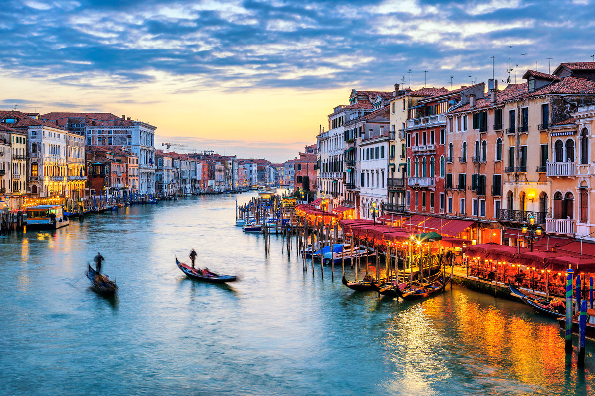 a picturesque view of the Grand Canal in Venice, Italy, with colorful buildings lining the waterway and gondolas floating along the canal.